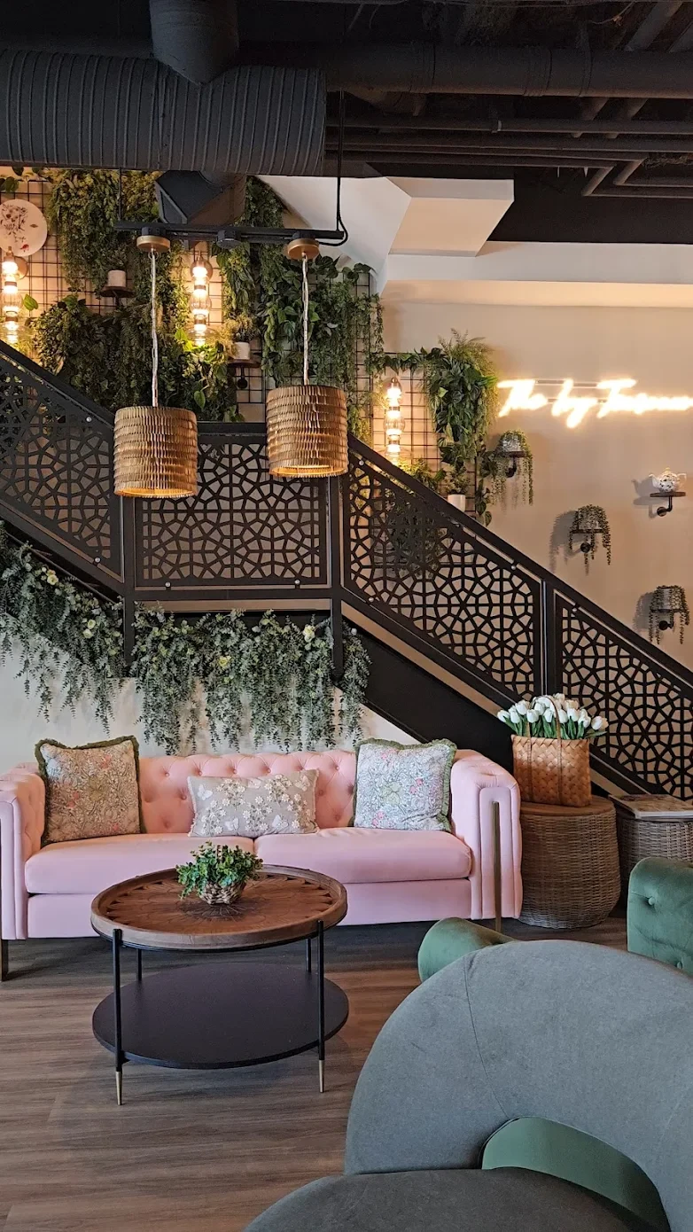 The Ivy staircase with pink velvet sofa and hanging greenery