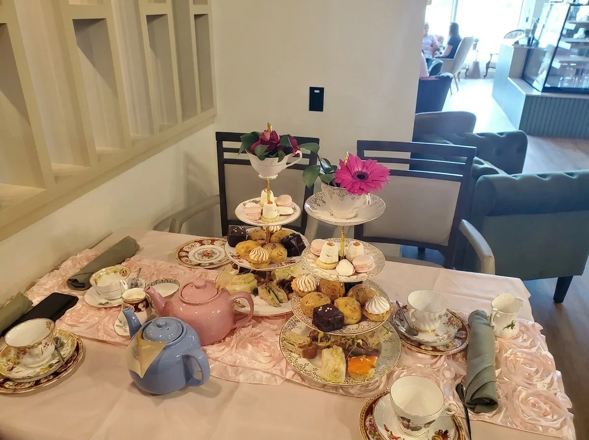Tiered afternoon tea spread with pastries and teapots